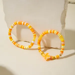 Détails de bracelets en perles Heishi faits main avec fleur orange et accents dorés