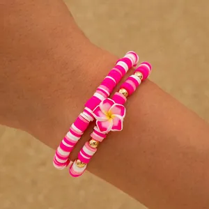 Bracelets bohèmes en perles heishi roses et blanches avec un pendentif fleur de frangipanier