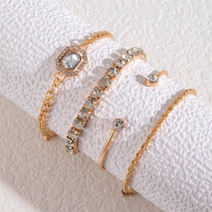 Détail d'un ensemble de 4 bracelets dorés avec mailles et cristaux scintillants