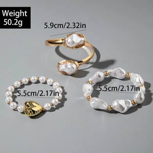 Detailed view of 3-piece set with liquid gold cuff, heart pendant, and pearl bracelets