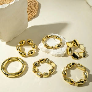 Detailed view of layered irregular gold metal bracelets with pearls and geometric beads
