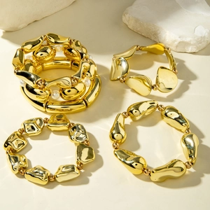 Close-up of four-piece gold bracelet set with liquid metal textures and pearl accents