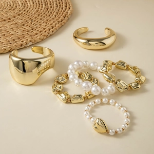 Five-piece gold jewelry set featuring liquid fold bangles, pearl bracelets, and heart ring