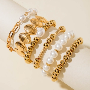 5-piece gold bracelet set with shell charms and artificial pearls on display