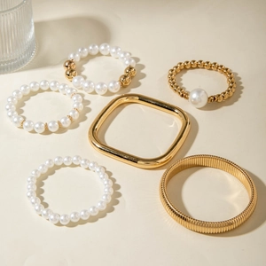 Detailed set of 6 gold metal bangles and white pearl beaded bracelets for women