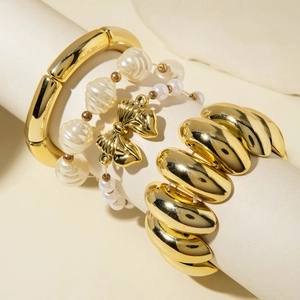 Chic gold liquid wrinkle cuff and irregular pearl bead bracelet set on a display stand