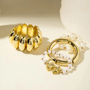 Three-piece set with gold wide elastic bracelet, sleek tube bangle and pearl bow bracelet