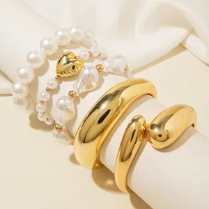 Polished gold liquid metal bangle set with irregular pearl and heart bead bracelets