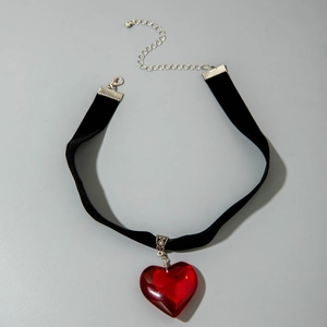 Close-up of gothic red heart pendant on black velvet choker necklace with silver clasp