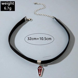 Macro view of gothic velvet choker with silver coffin pendant and red gemstone