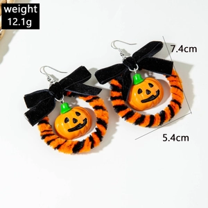 Detail van Halloween pompoen oorbellen met fluwelen strikjes en pluche ringen formaat