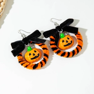 Halloween pompoen oorbellen met fluwelen strikken en oranje pluche ringen op wit