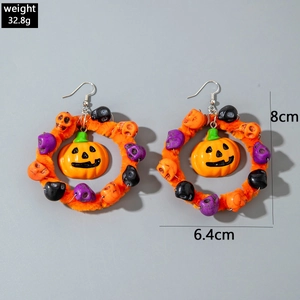 Detailopname van Halloween ringoorbellen met fluwelen pompoenen en schedeltjes