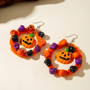 Detail van Halloween pompoen oorbellen met oranje pluche hoepels en schedelkralen