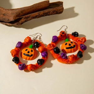 Macro-opname van Halloween pompoen oorbellen met kleurrijke schedels en pluchen ringen