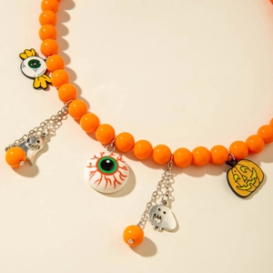 Close-up of Halloween beaded necklace with orange acrylic beads and pumpkin ghost pendants