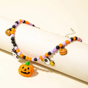 Close-up of Halloween beaded necklace with pumpkin and ghost charms on a scroll