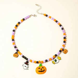 Detailed view of Halloween beaded necklace with pumpkin and ghost charms on white backdrop