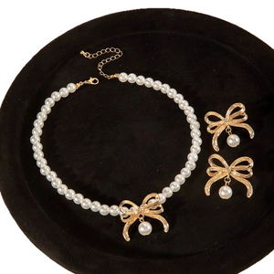 Elegante set collana di perle con ciondolo a fiocco dorato e orecchini a lobo coordinati
