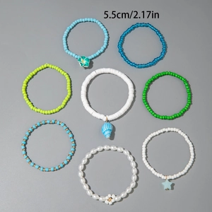 Detail of 8-piece bohemian beaded bracelet set with shell and flower charms for women