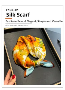 Gros plan d'un foulard carré en soie à imprimé tournesol dans son coffret cadeau