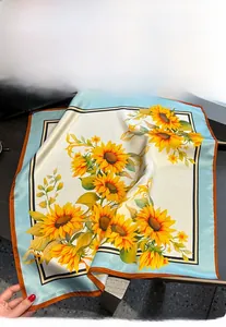 Détail de la texture d'un foulard en soie à imprimé tournesol avec bordures roulées sur pierre