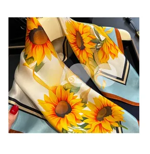 Détail du foulard en soie montrant des tournesols aux teintes jaune et bleu vif