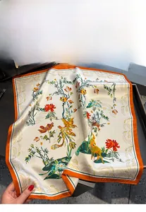 Détail d'un foulard carré en soie présentant des motifs traditionnels de phénix et de fleurs