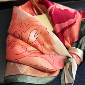 Seidenschal mit Blumenmuster in Rot und Grün, gebunden als dekoratives Accessoire
