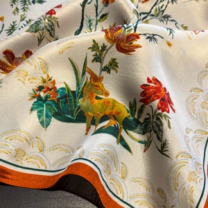 Foulard en soie luxueux avec bordure orange et imprimé floral artistique en plis doux