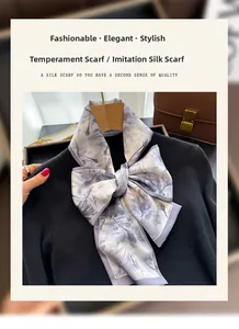Détail d'un foulard en soie imprimé floral violet noué en nœud sur un pull noir élégant