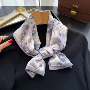 Élégant foulard en soie à motif libellule sur pull noir avec un décor chic et raffiné