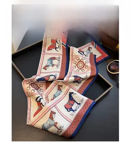 Close-up of a silk twilly scarf with horse motifs paired with a brown leather bag