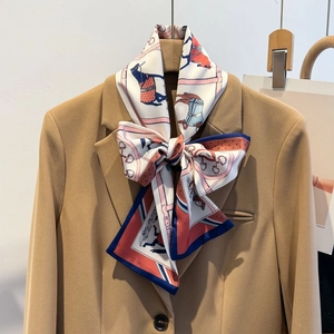 Equestrian print silk scarf with horse motifs styled on a khaki blazer for a chic look