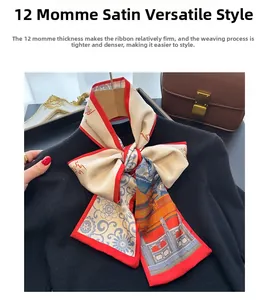 Détail d'un twilly en soie à motifs Chinoiserie noué sur un pull noir avec bord rouge