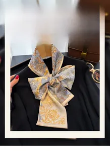 Vista dettagliata di un elegante foulard in seta sintetica con motivi gialli e blu