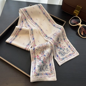 Dettaglio di un foulard in seta con stampa floreale su un vassoio di moda in pelle