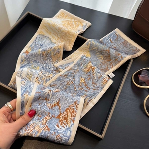 Elegante foulard twilly in seta a fiori presentato in un vassoio di pelle di lusso