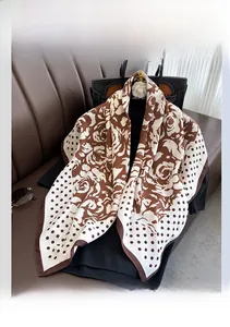 Close-up of floral and polka dot silk scarf draped over a black knit sweater