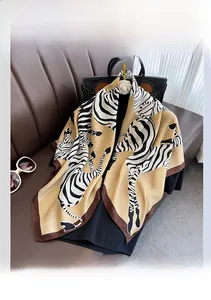 Dettaglio di un foulard in seta con stampa zebra gialla e bordo marrone elegante