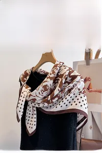 Close-up of silk-like scarf with rose floral prints and vintage polka dot pattern detail