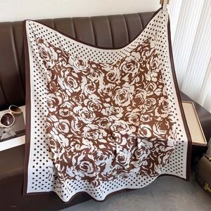 Brown and beige polka dot scarf with rose pattern on a leather background