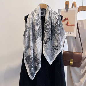 Detail of a silky floral print scarf featuring palm trees and classical architecture motifs