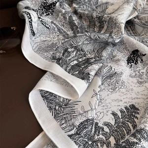 Detail of floral and leopard print on a black and white vintage scarf with palm leaves