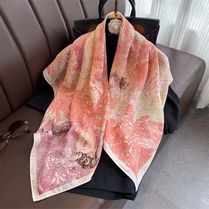 Detail of floral and tropical print silk scarf draped on a chic black sweater outfit