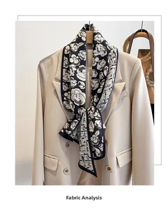 Detail of a black and white floral pattern silk scarf tied on a beige suit collar