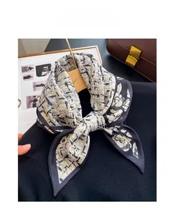 Close-up of silk-like scarf with grey plaid and dark blue floral pattern around neck