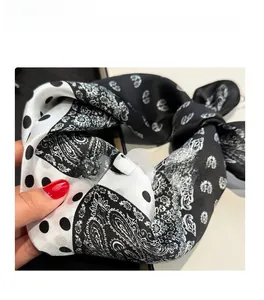 Detail of silk scarf showing paisley and polka dot print with smooth texture