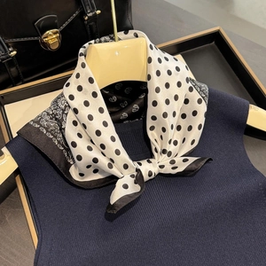 French silk scarf with white polka dots and paisley patterns on a display hanger