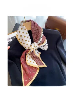 Close-up of wine red paisley and polka dot silk scarf draped on a black sweater